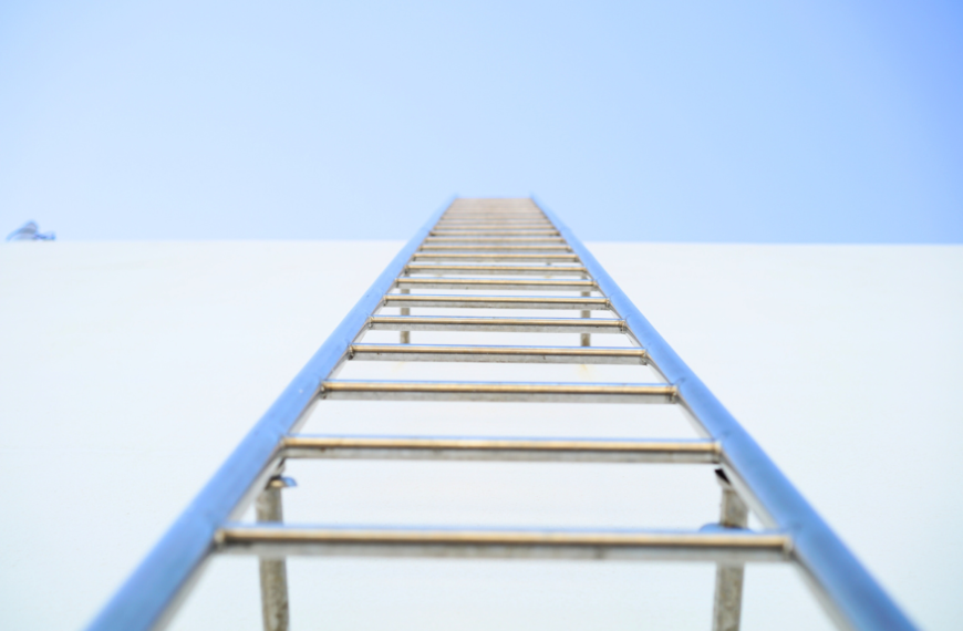 Escalera. Estructura piramidal de bloques sobre fondo oscuro — esquema piramidal disfrazado de inversión, señales de alerta financiera