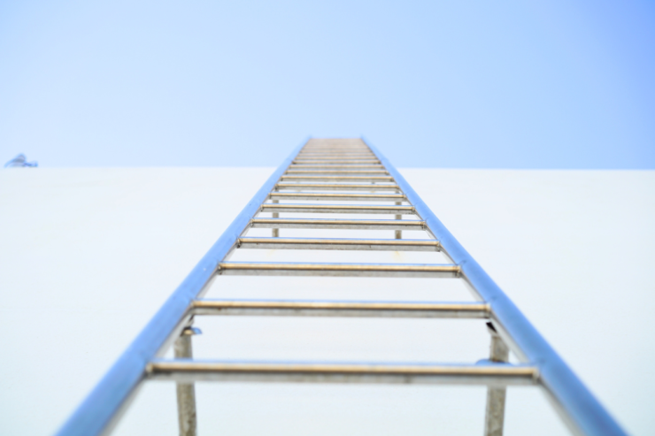 Escalera. Estructura piramidal de bloques sobre fondo oscuro — esquema piramidal disfrazado de inversión, señales de alerta financiera